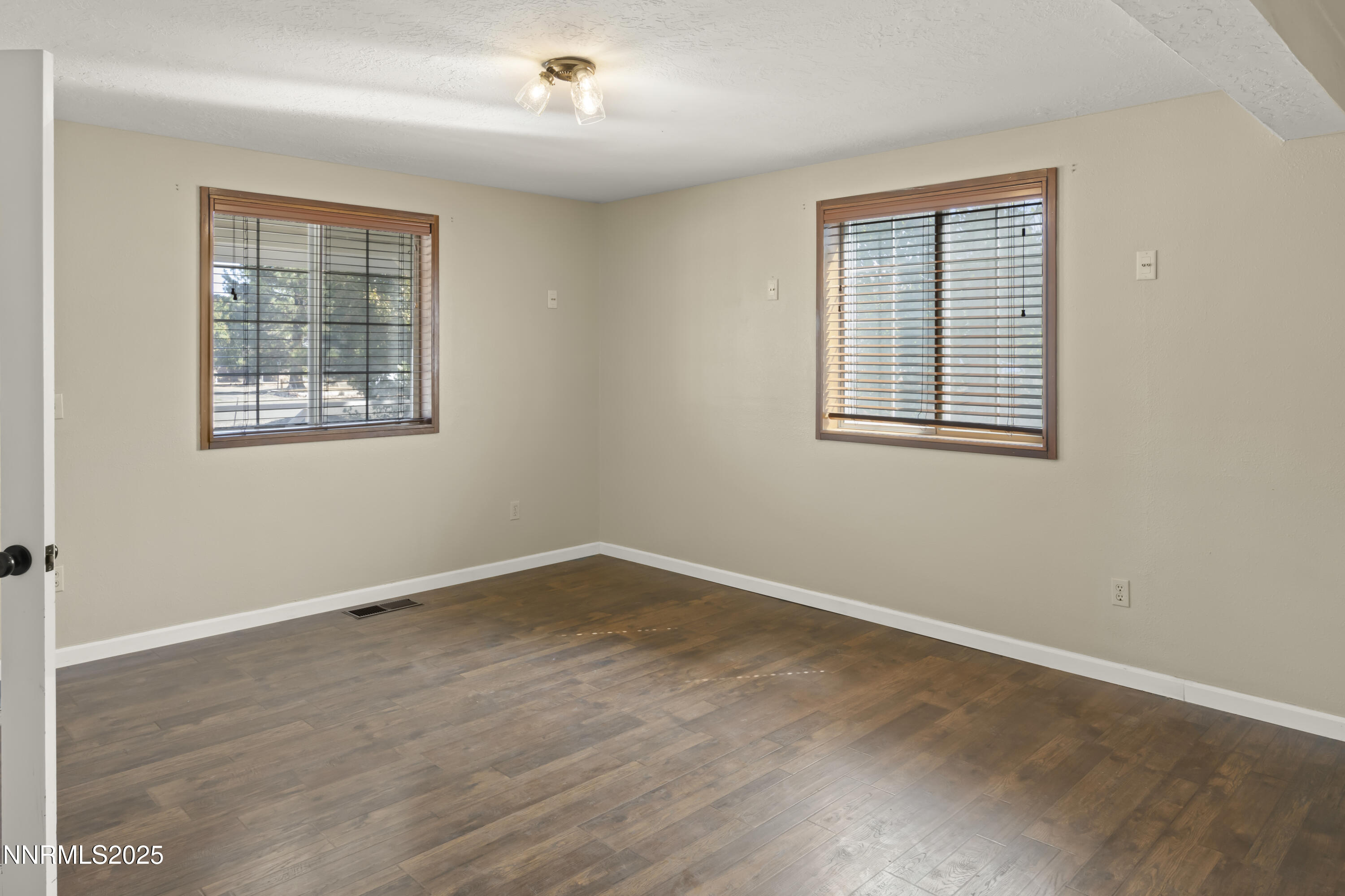 1165 Farm Lane Fernley, NV 89408 - Photo 9 of 38 an empty room with wooden floor and windows