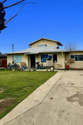 a view of a big yard with table and chairs under an umbrella