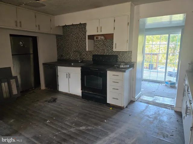 a kitchen with stainless steel appliances granite countertop a stove a refrigerator and a granite counter tops with white cabinets