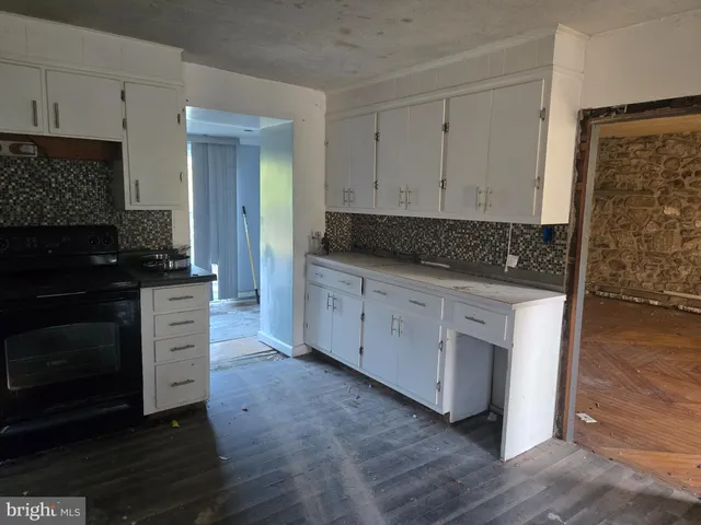 a kitchen with white cabinets and a stove