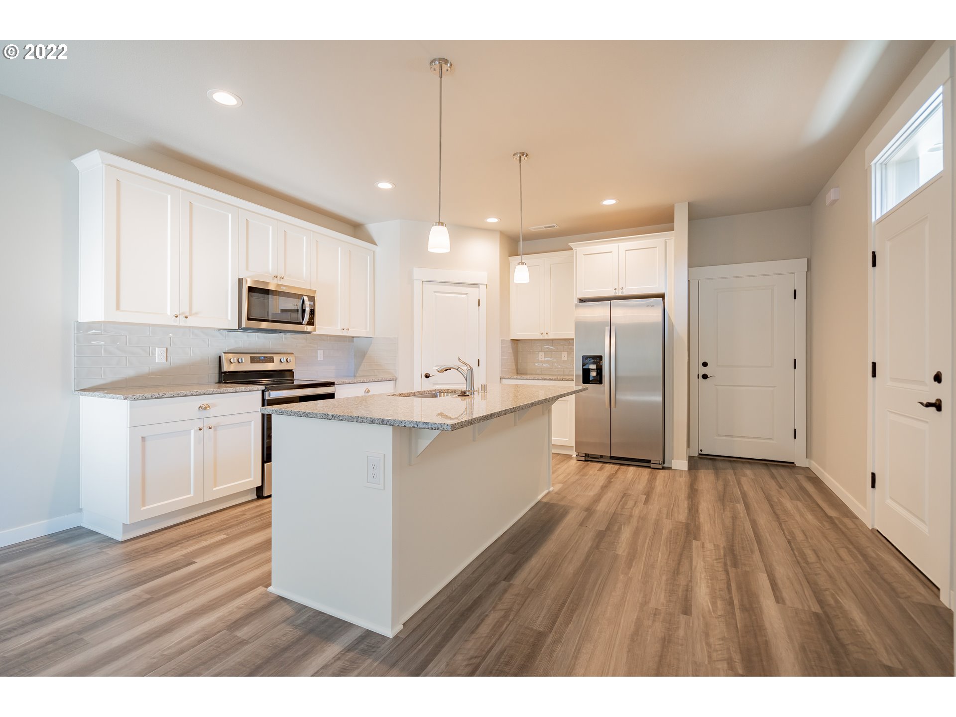 7225 South 13th Street Ridgefield, WA 98642 - Photo 2 of 30 a kitchen with white cabinets and stainless steel appliances