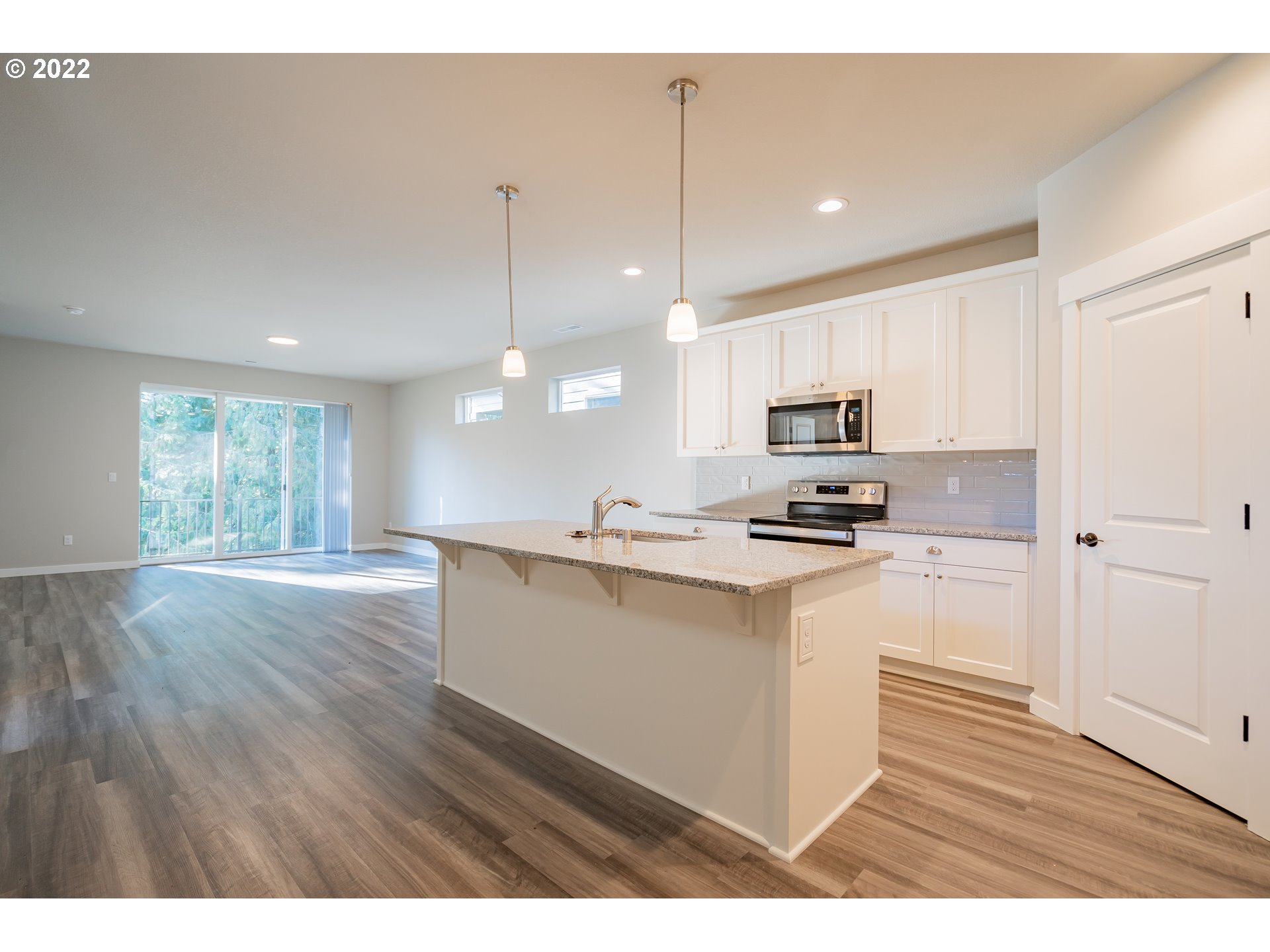 7225 South 13th Street Ridgefield, WA 98642 - Photo 6 of 30 a kitchen with stainless steel appliances granite countertop a refrigerator a sink dishwasher a stove and white countertops with wooden floor