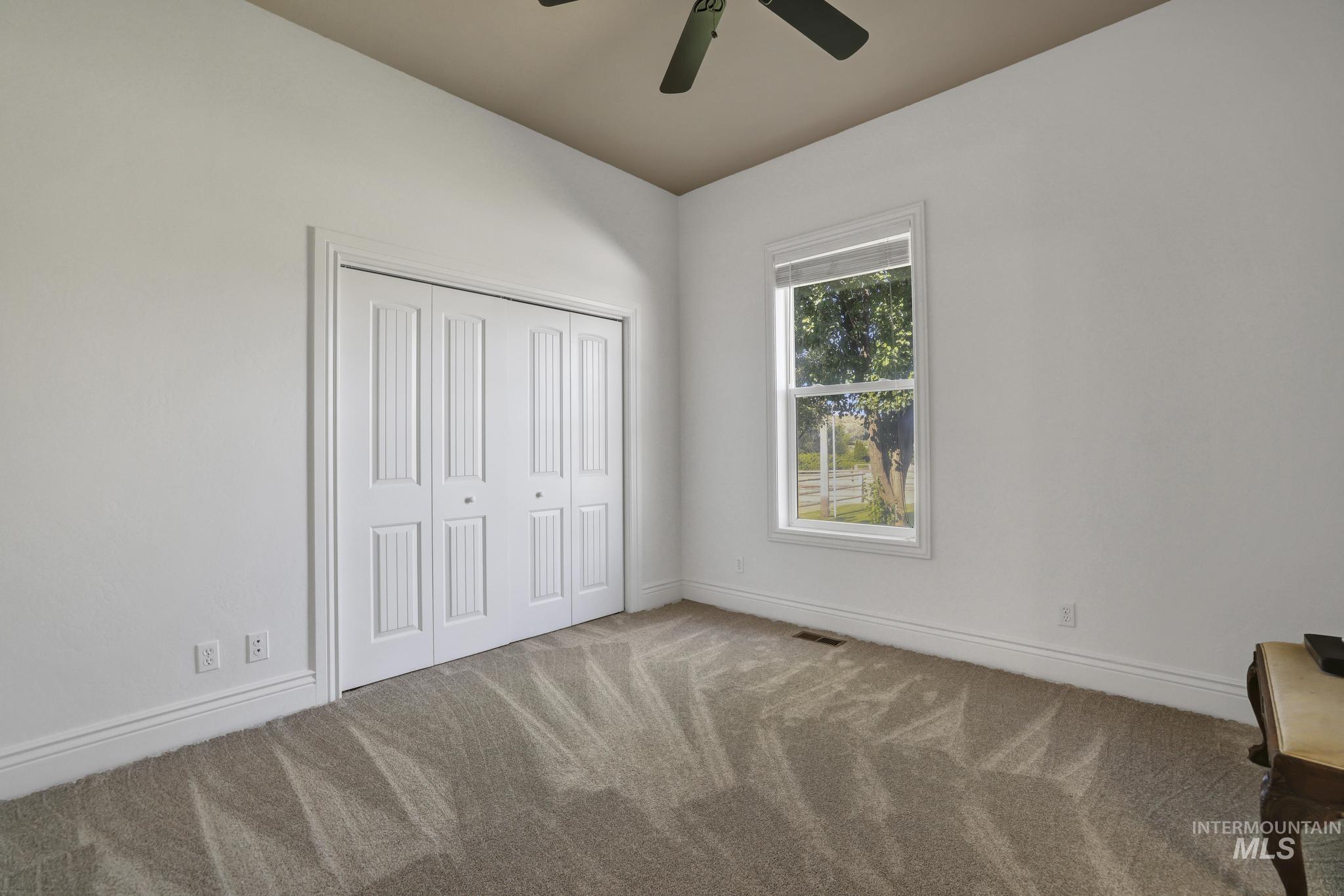 1301 Kanaka Rapids Road Buhl, ID 83316 - Photo 33 of 50 Room featuring neutral carpeting, white walls, and a vaulted ceiling with a fan