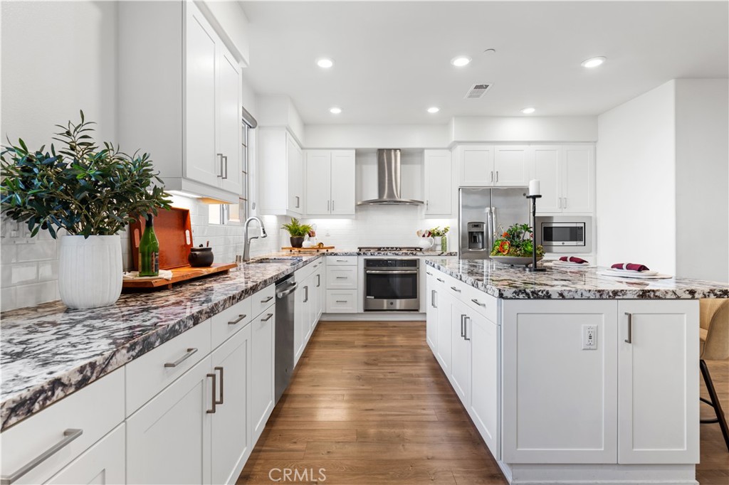 171 Cadence Irvine, CA 92618 - Photo 14 of 27 a kitchen with granite countertop a sink and stove top oven