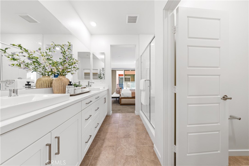 171 Cadence Irvine, CA 92618 - Photo 20 of 27 a en suite bathroom with a double vanity sink and mirror