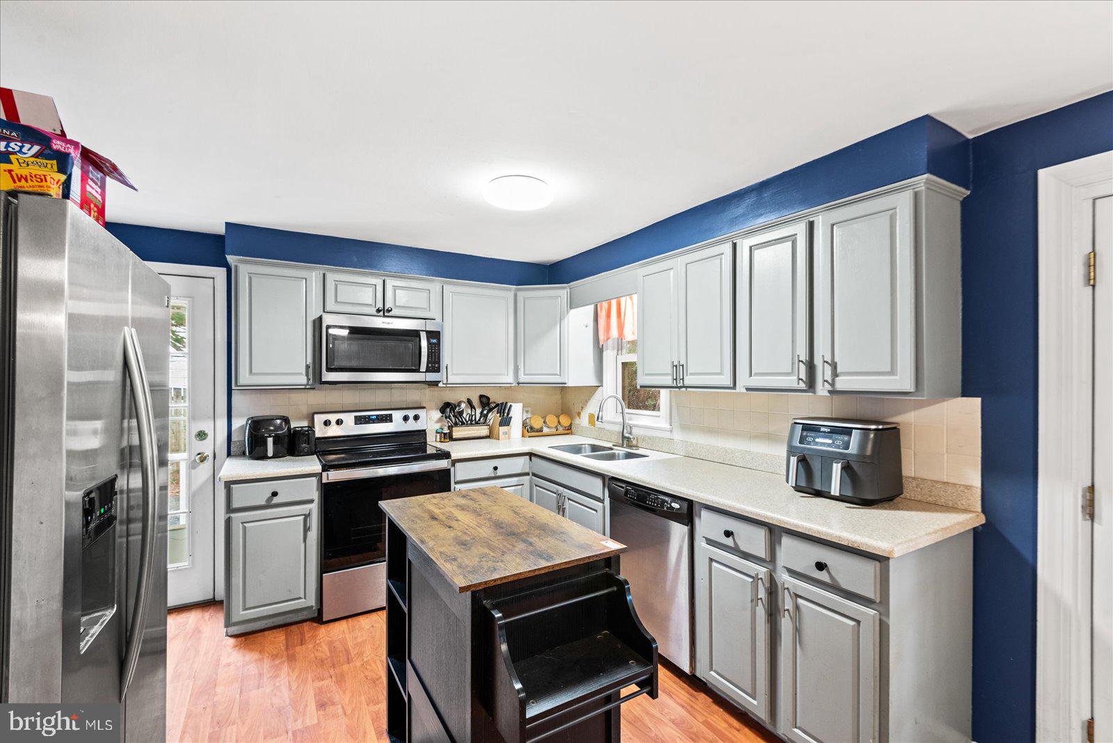 8441 Pamunkey Road Spotsylvania, VA 22551 - Photo 3 of 32 a kitchen with stainless steel appliances a stove a sink a refrigerator and white cabinets