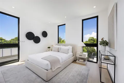 a bedroom with a bed and a large mirror with the potted plant