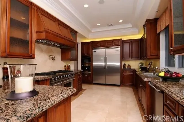 a kitchen with granite countertop a stove a sink and a refrigerator