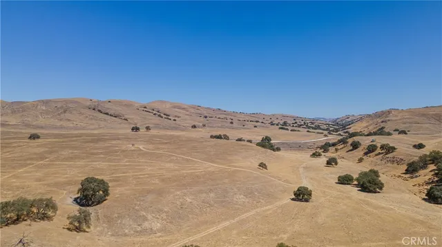 an aerial view of a house with a yard and ocean view
