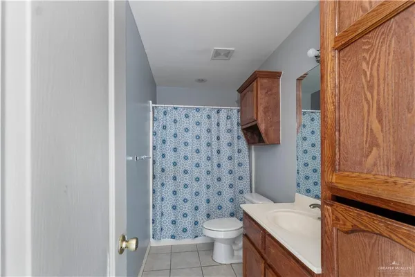 a bathroom with a sink a toilet and shower curtain