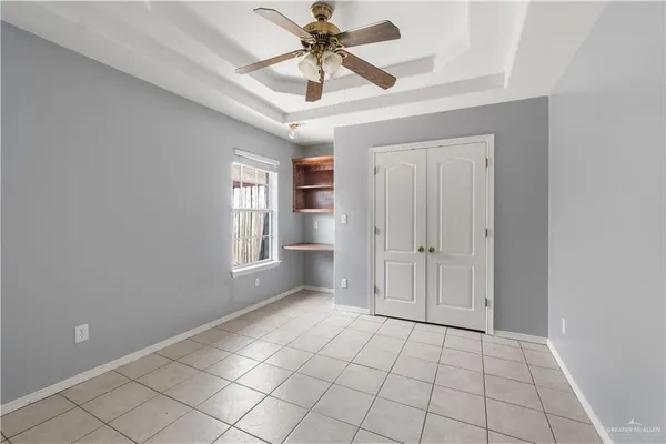 a view of an empty room and window chandelier fan