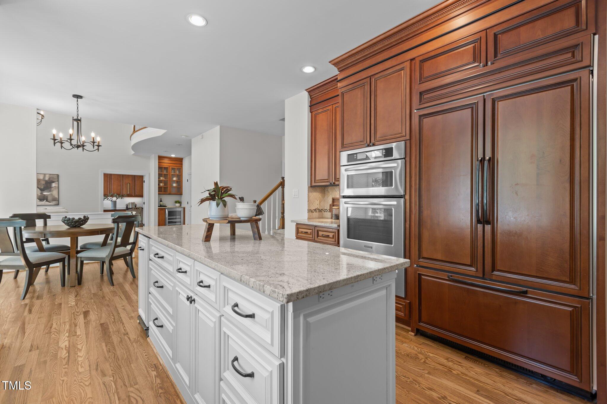103 Ticonderoga Road Cary, NC 27519 - Photo 16 of 65 a kitchen with stainless steel appliances granite countertop a refrigerator a stove and a dining table with wooden floor