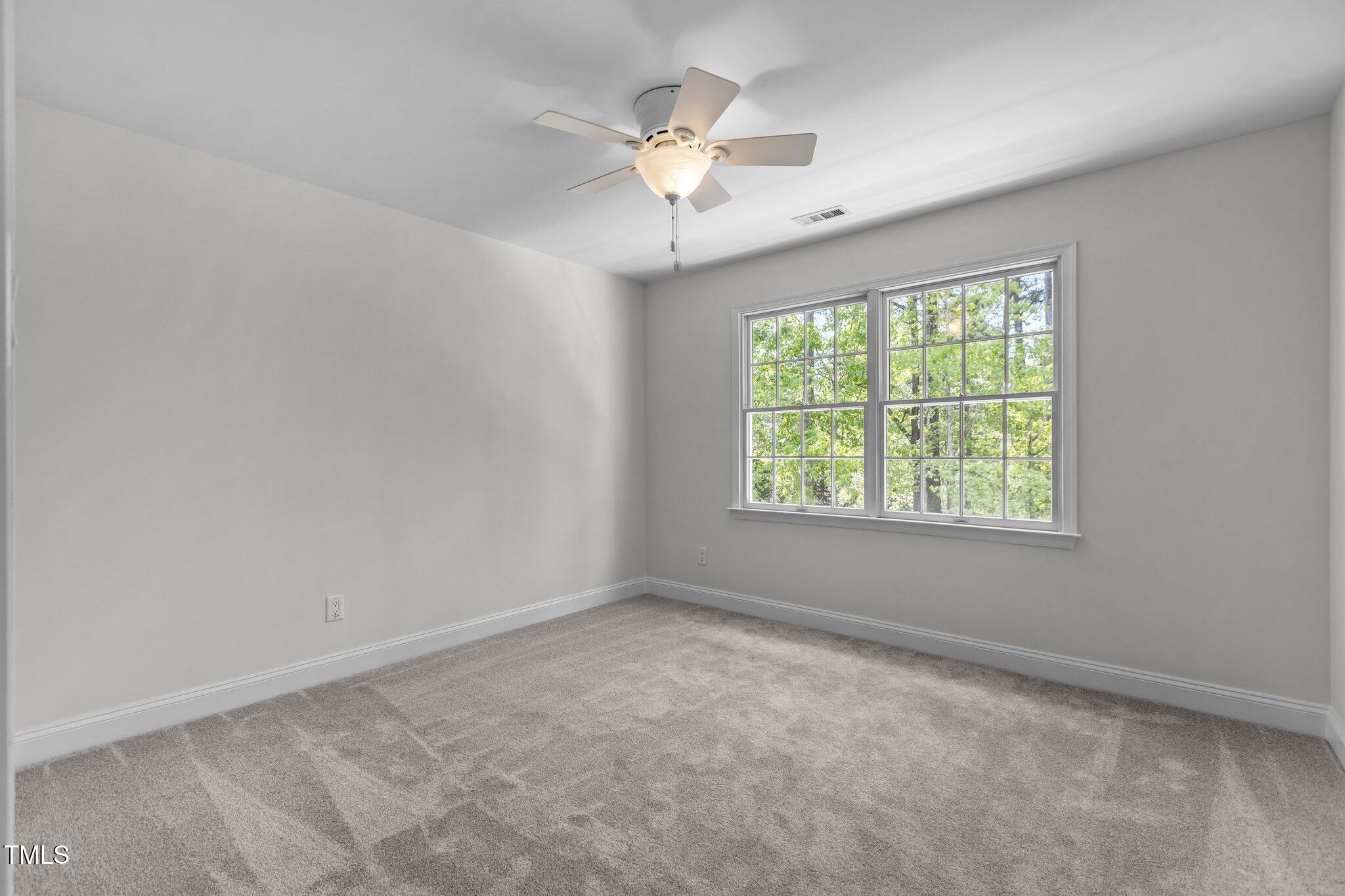 103 Ticonderoga Road Cary, NC 27519 - Photo 35 of 65 an empty room with a window and a chandelier fan