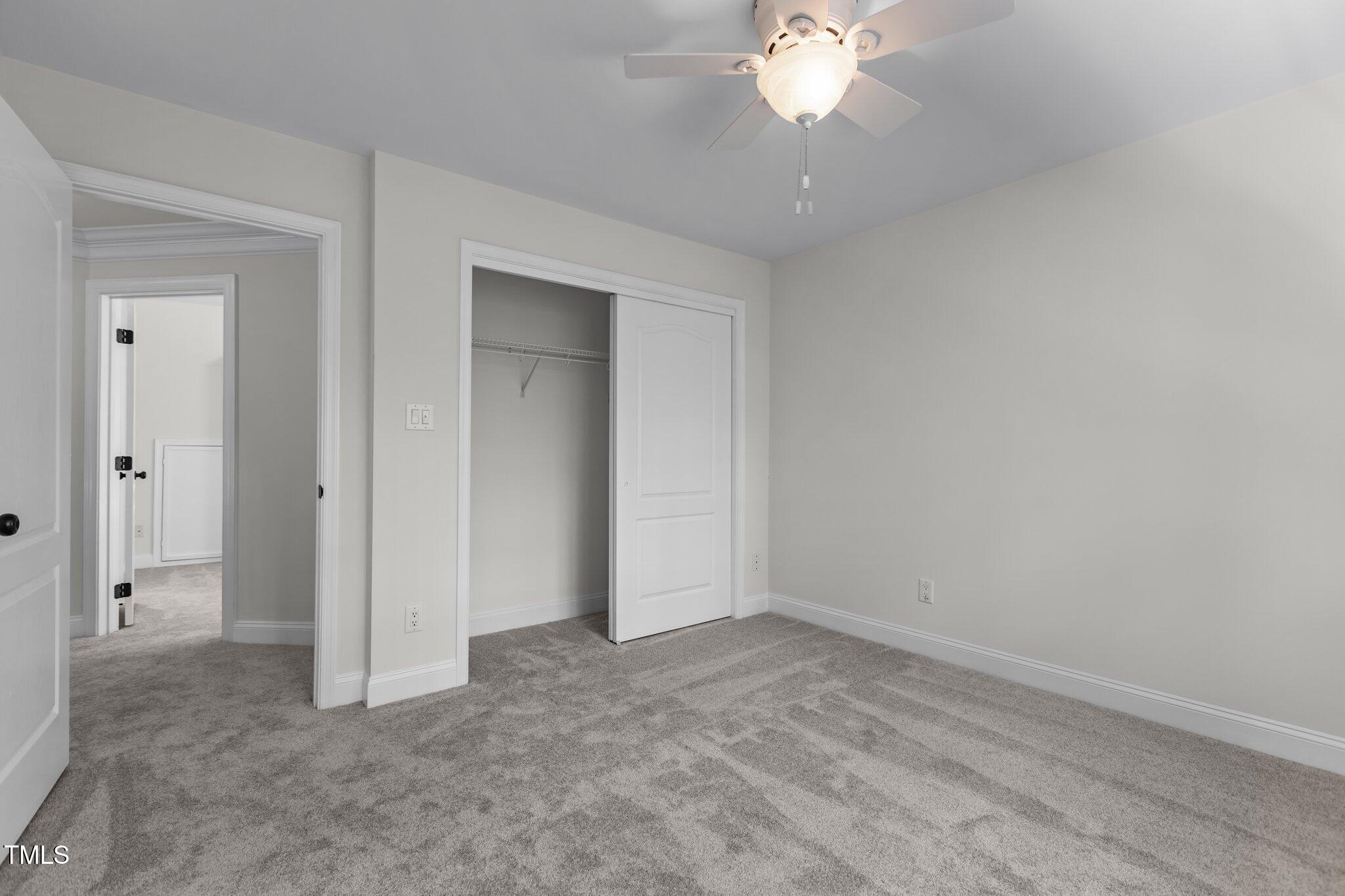 103 Ticonderoga Road Cary, NC 27519 - Photo 36 of 65 an empty room with a chandelier fan and closet area