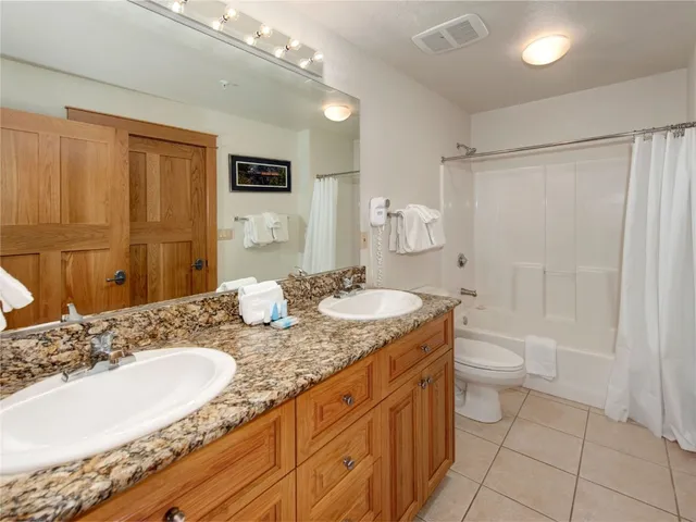 a bathroom with a granite countertop sink a mirror and a shower