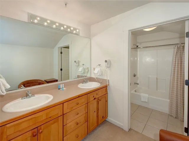 a bedroom with a large bed and a lamp on table