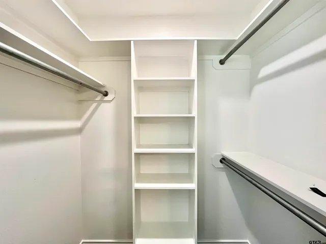 a hallway with white cabinets and a wooden floors