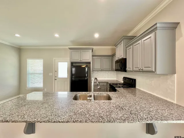 a kitchen with stainless steel appliances granite countertop a sink stove and refrigerator