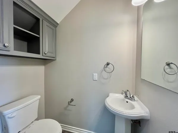 a bathroom with a toilet sink and mirror