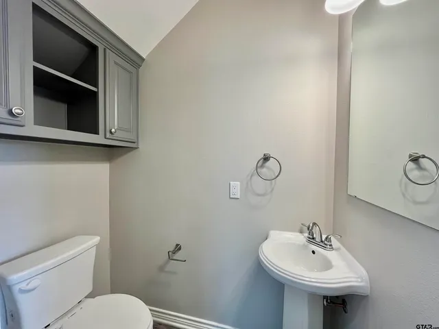 a bathroom with a toilet sink and mirror