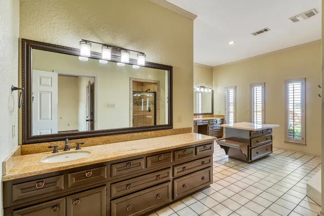 a spacious bathroom with double vanity and a mirror