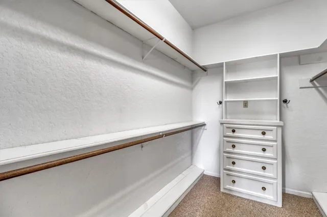 a view of walk in closet with empty racks