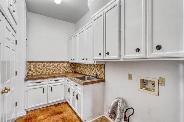 a kitchen with granite countertop white cabinets and white appliances