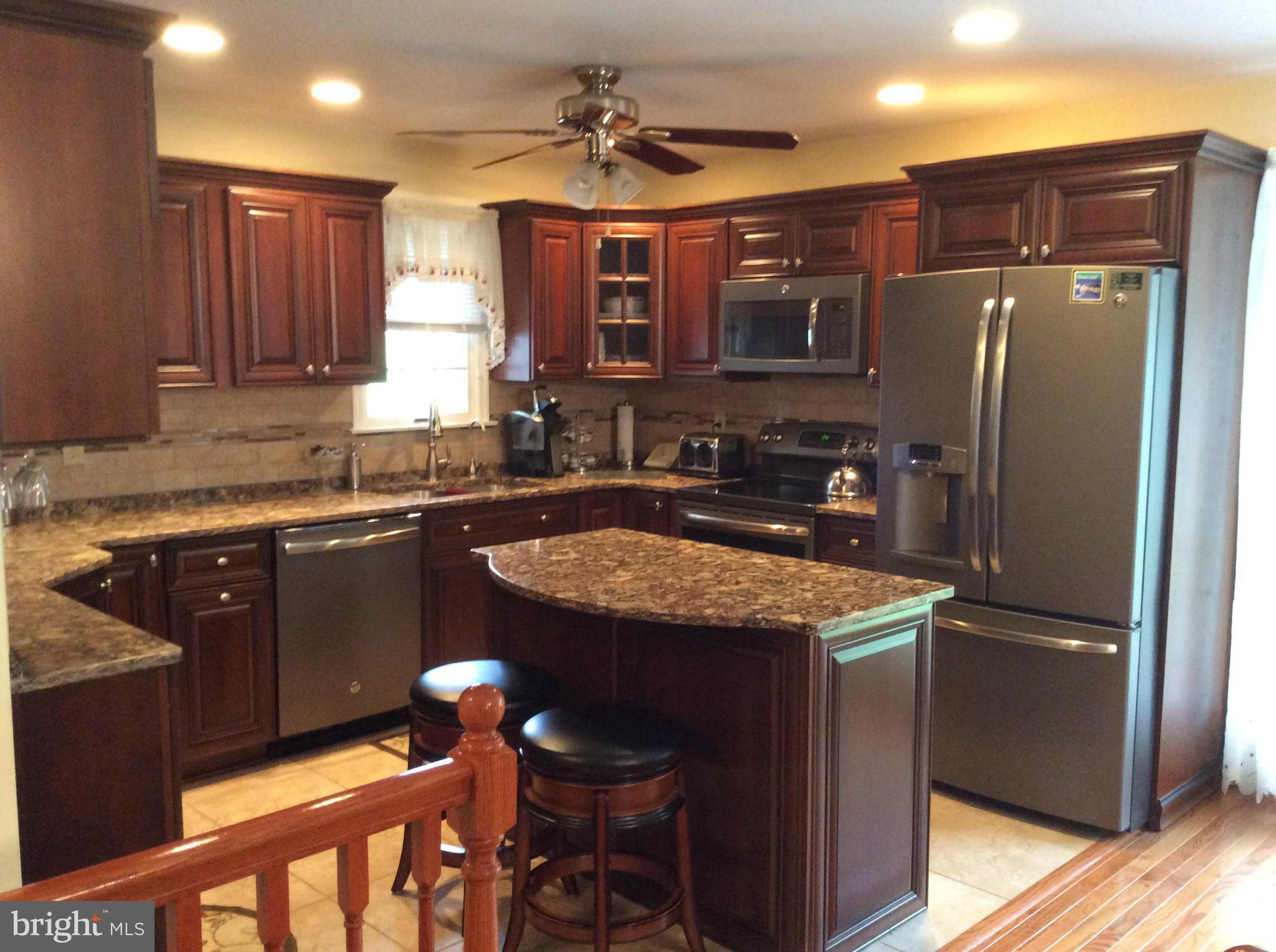 2601 Old Washington Road Westminster, MD 21157 - Photo 6 of 27 a kitchen with stainless steel appliances granite countertop wooden cabinets a refrigerator and a stove