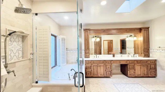 a bathroom with a tub a sink and a large mirror