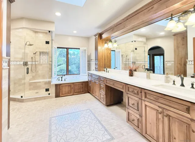 a spacious bathroom with a double vanity sink large mirror and a bathtub