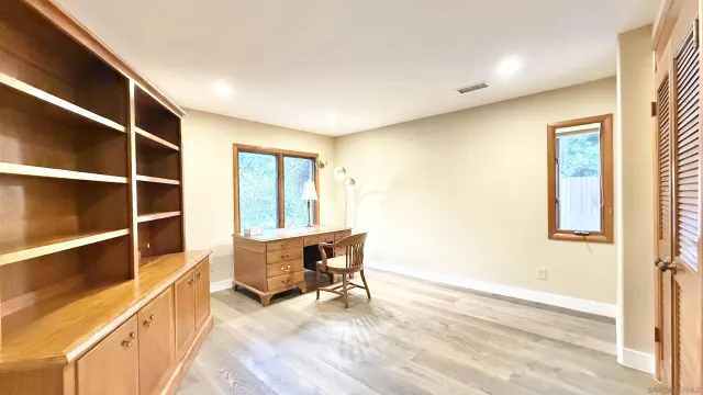 a view of a room with wooden floor and furniture