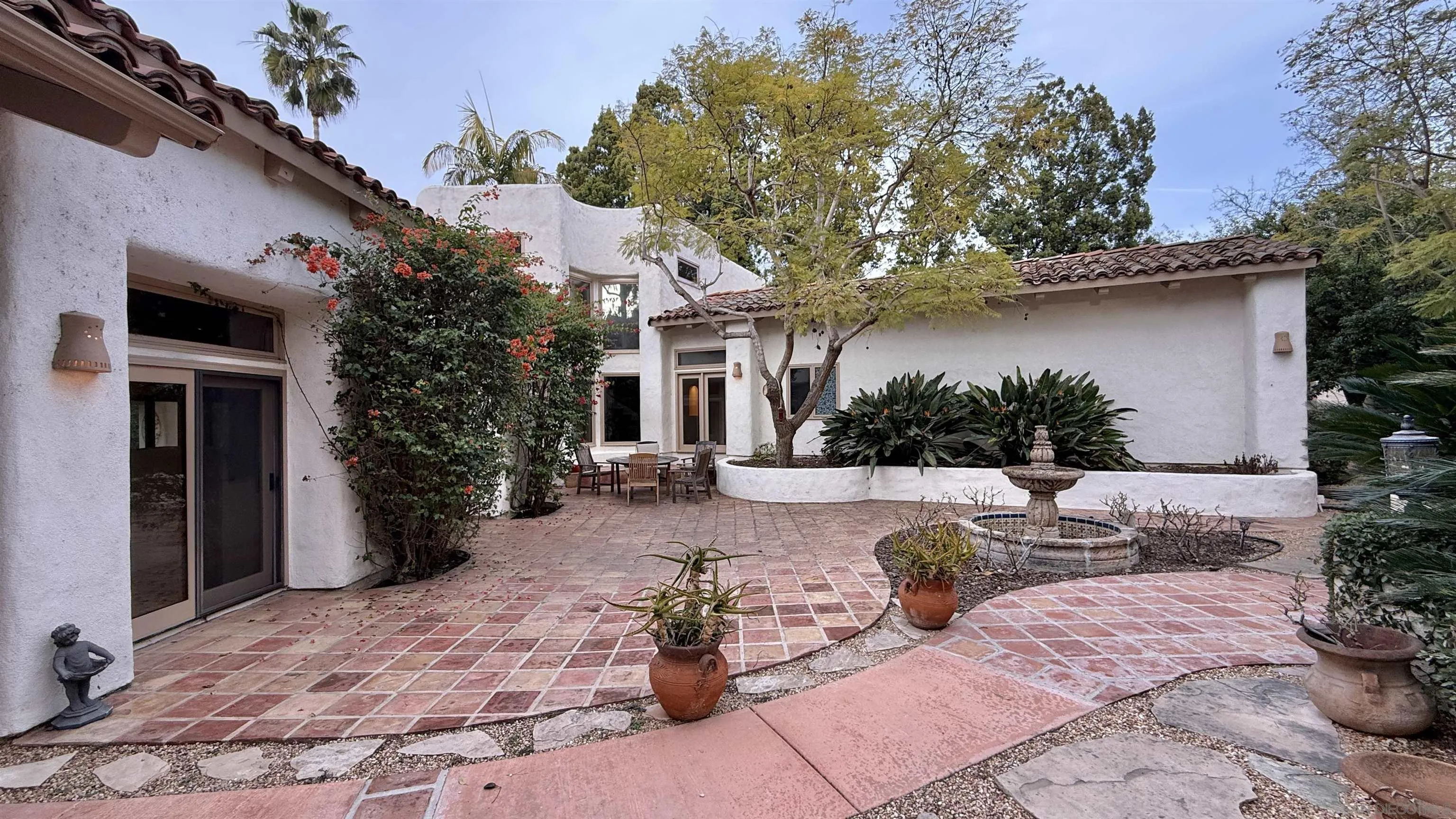 16722 Via Lago Azul Rancho Santa Fe, CA 92067 - Photo 27 of 28 a view of a patio with couches table and chairs under an umbrella
