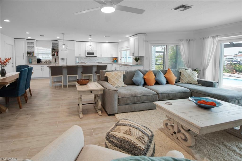 19 East Pelican Street Naples, FL 34113 - Photo 11 of 50 a living room with furniture and a dining table with kitchen view