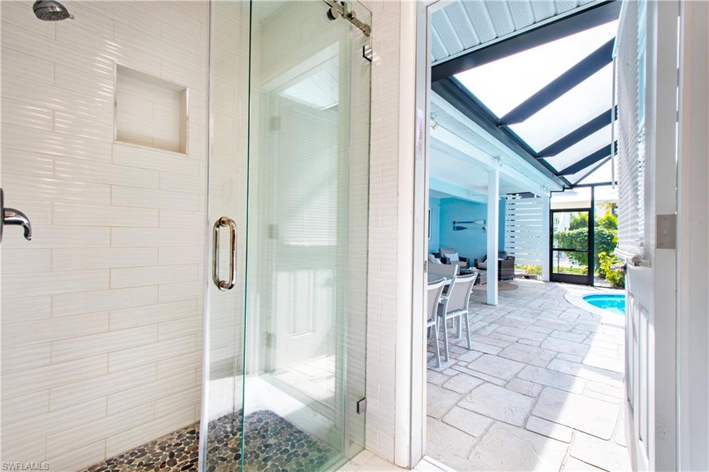 19 East Pelican Street Naples, FL 34113 - Photo 14 of 50 a view of a hallway with bathroom and glass door