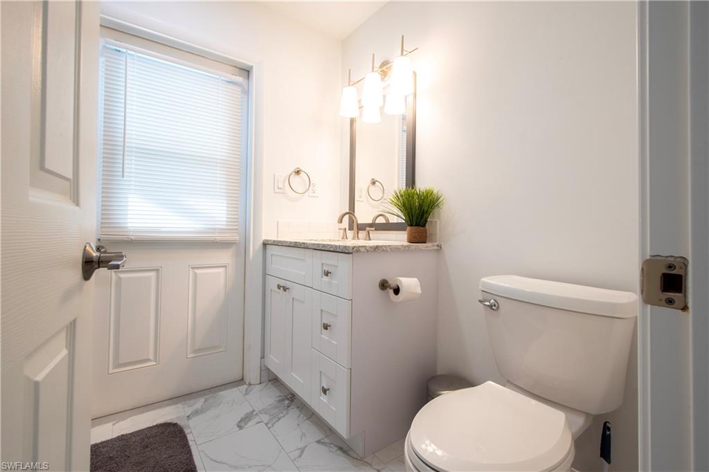 19 East Pelican Street Naples, FL 34113 - Photo 15 of 50 a bathroom with a toilet a sink and a window