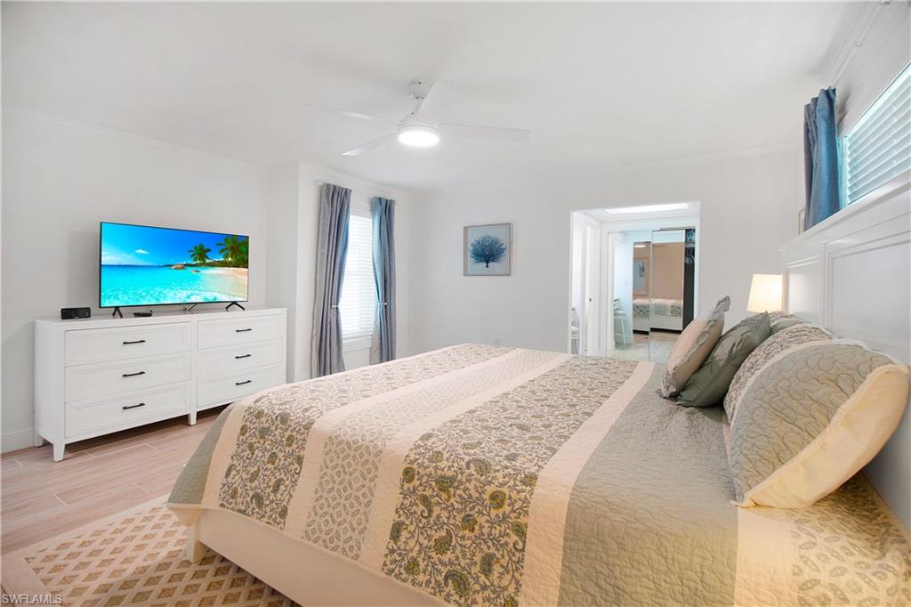 19 East Pelican Street Naples, FL 34113 - Photo 17 of 50 a bedroom with a bed and a flat screen tv