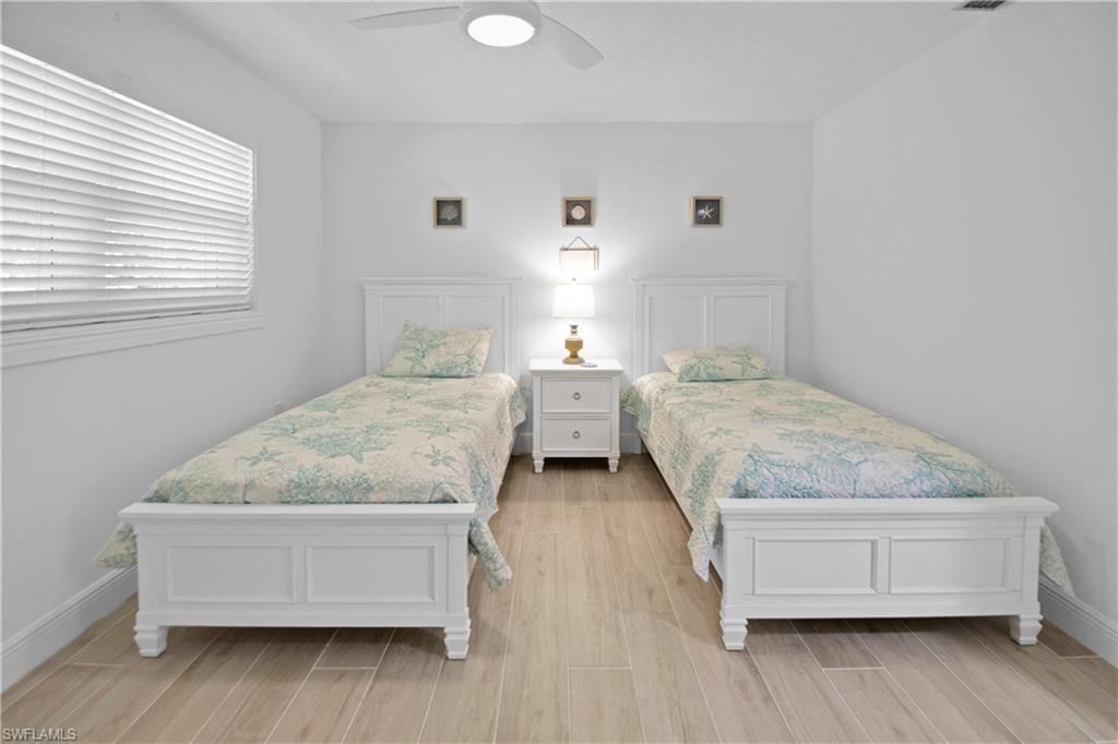 19 East Pelican Street Naples, FL 34113 - Photo 19 of 50 a bedroom with a bed and wooden floor