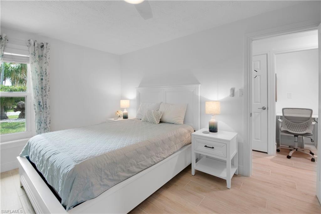 19 East Pelican Street Naples, FL 34113 - Photo 22 of 50 a bedroom with a bed and a chair