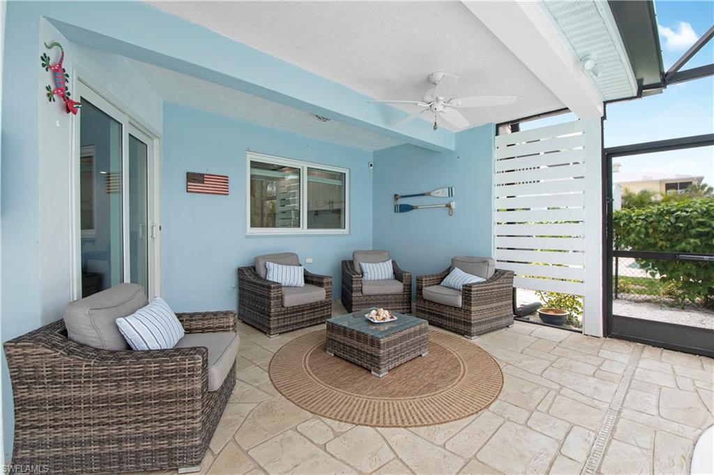 19 East Pelican Street Naples, FL 34113 - Photo 24 of 50 a living room with furniture and a floor to ceiling window