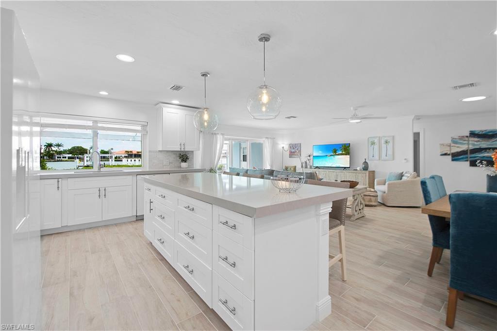 19 East Pelican Street Naples, FL 34113 - Photo 29 of 50 a kitchen with stainless steel appliances kitchen island granite countertop a sink and cabinets