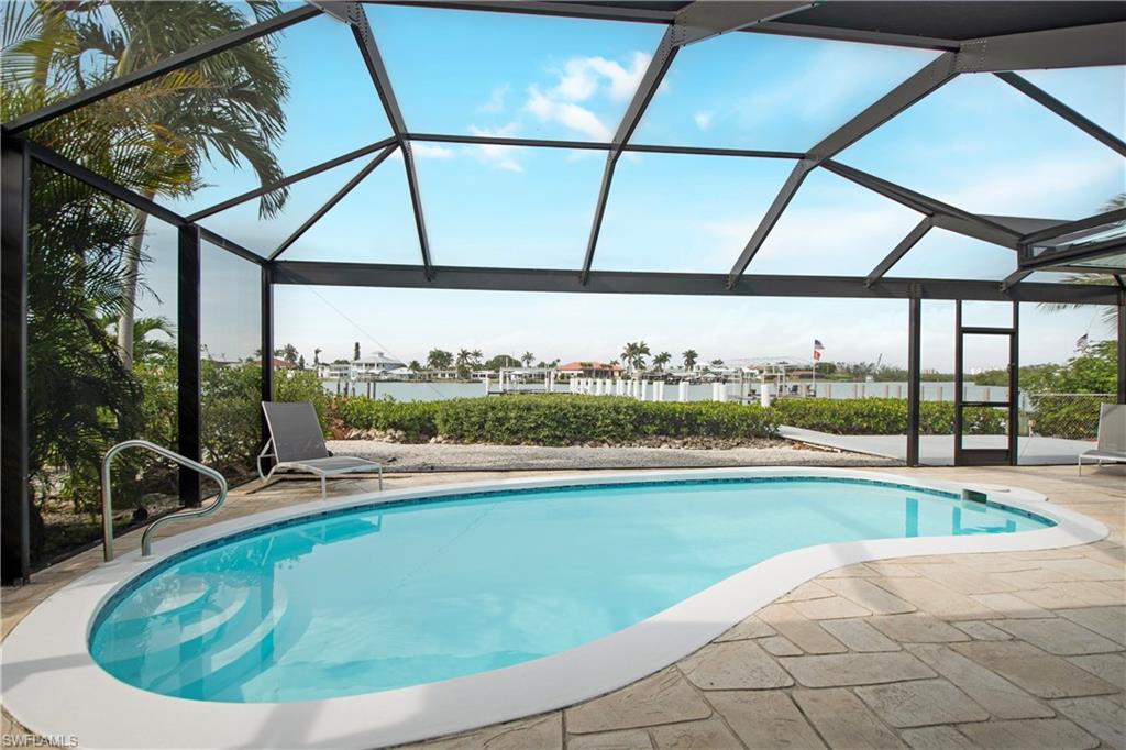 19 East Pelican Street Naples, FL 34113 - Photo 32 of 50 a view of a swimming pool and a yard