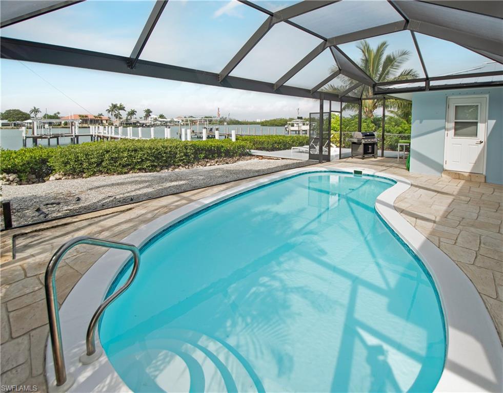 19 East Pelican Street Naples, FL 34113 - Photo 34 of 50 a view of a swimming pool with a patio