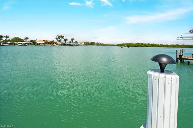 a view of a lake with table and chairs in the back