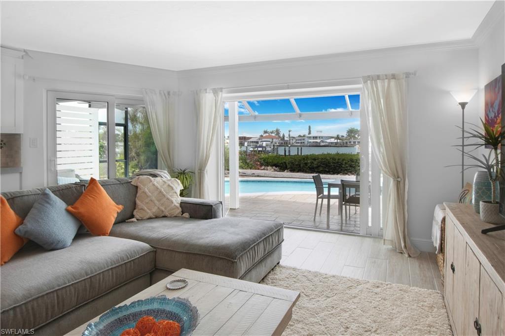 19 East Pelican Street Naples, FL 34113 - Photo 7 of 50 a living room with furniture and a flat screen tv