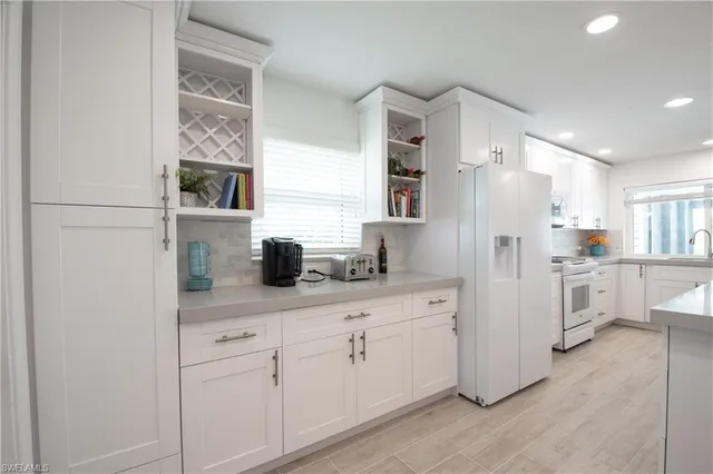 a kitchen with white cabinets and white appliances