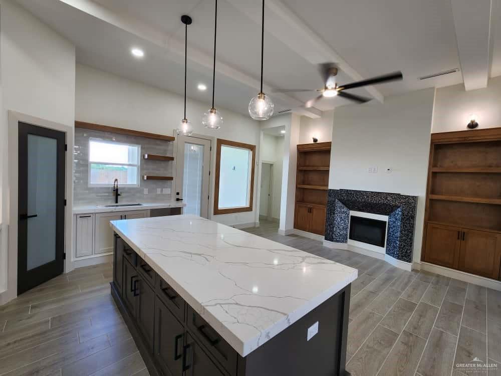1003 Azalea Street Mission, TX 78573 - Photo 7 of 17 a large kitchen with kitchen island a sink stainless steel appliances and cabinets