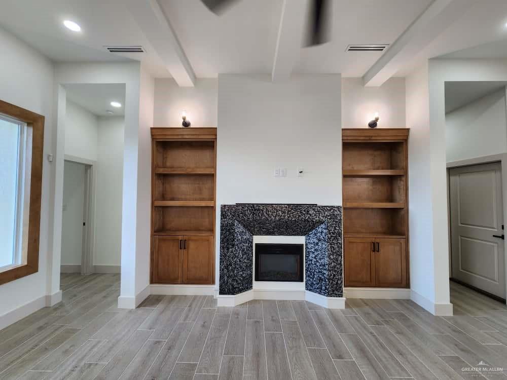 1003 Azalea Street Mission, TX 78573 - Photo 8 of 17 wooden floor in an empty room with a fireplace
