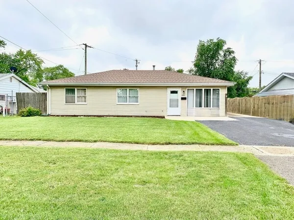 a view of a house with a yard and potted plants