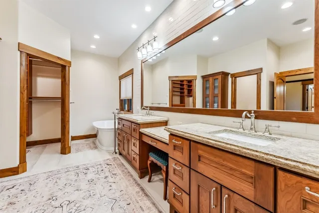 a bathroom with a granite countertop sink a mirror a shower and a bathtub
