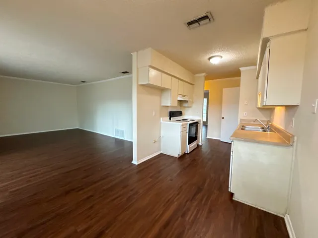 a view of kitchen with cabinets appliances wooden floor and electronic appliances